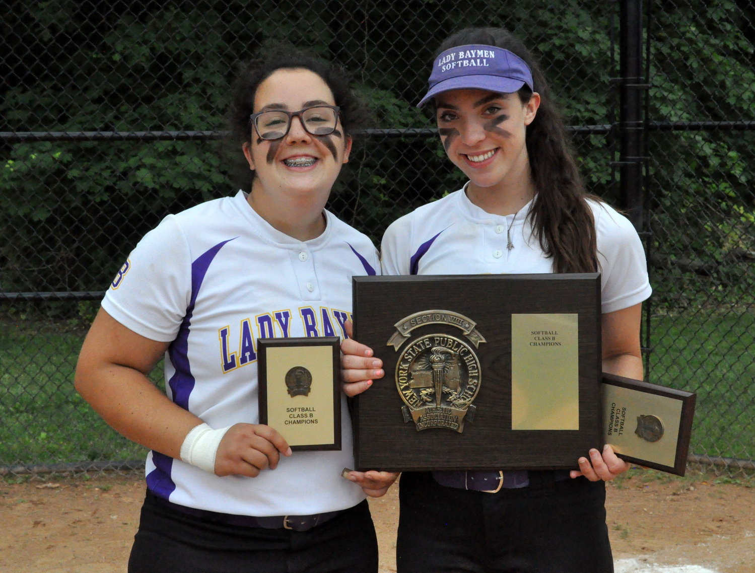 Seniors Emma Guarini, left, and Skylar McEvoy display the Nasssau County Class B championship hardware after Oyster Bay's 3-1 win over Wheatley on Saturday.