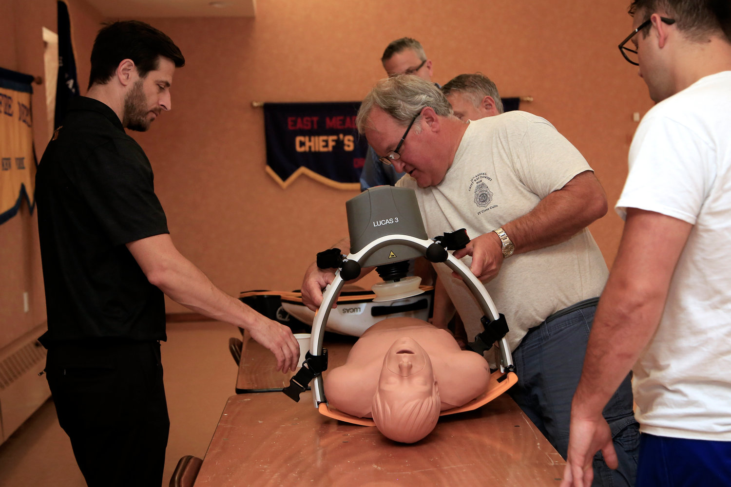 Ryan Pinnix, left, a representative of the Lund University Cardiopulmonary Assist System, helped Paul Kosiba, chief of the East Meadow Fire Department, use the Lucas, a mechanical device that can replace CPR.