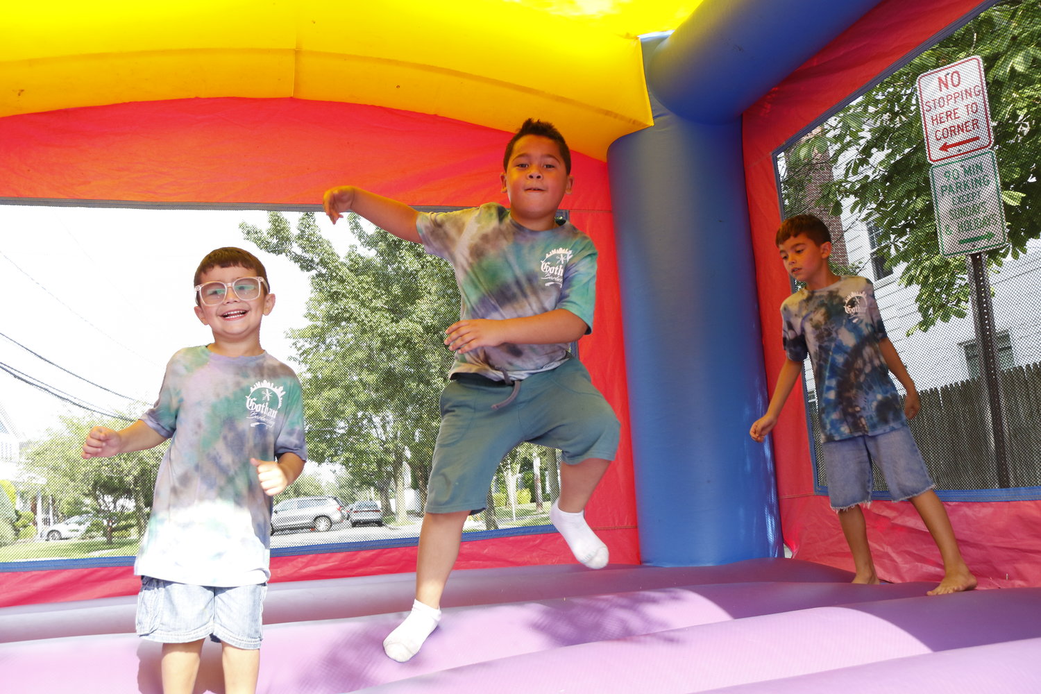 Jiovani Torres, 4, left, Mason Clinton, 8, and Julian Torres, 7, enjoyed the bouncy house during Gotham Barbershop’s grand opening in West Hempstead last Saturday.