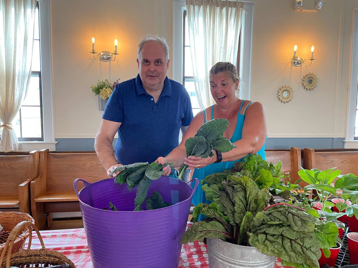 Volunteers Carl Bucking, left, and Jennifer Henning showed off some of the garden’s fresh produce.