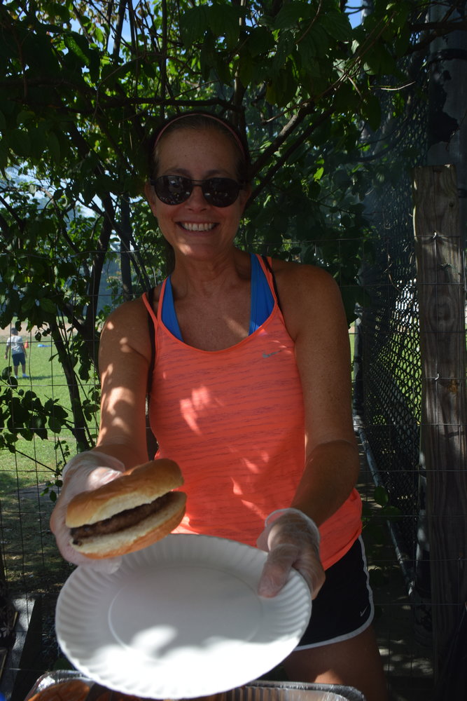 North Woodmere resident Kim Diluzio served a hamburger to a hungry reporter.