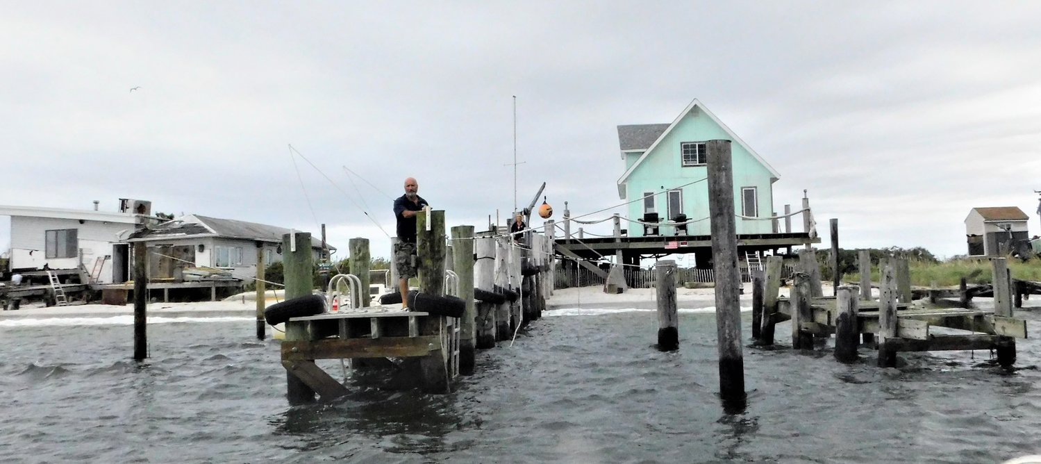 Tommy Famiglietti stood on the dock of the mint-green bay house that he co-constructed with Sue Lyons on Meadow Island.