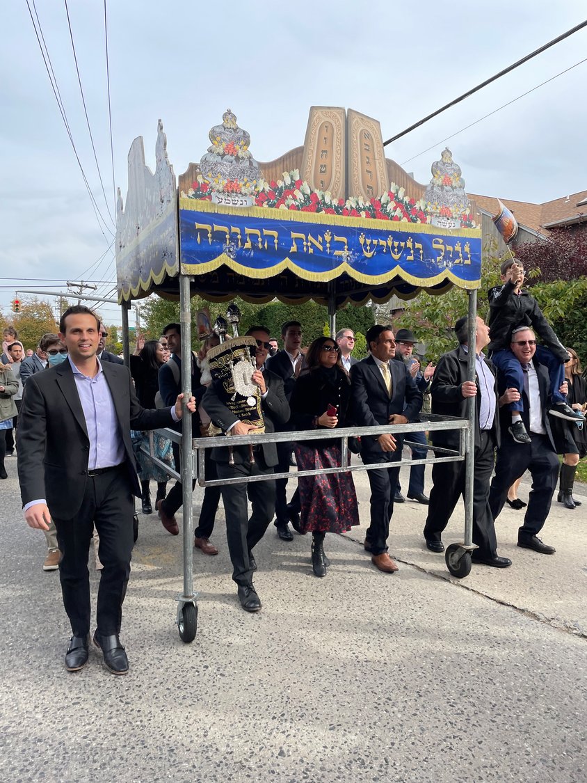 Family and congregation members paraded through Merrick with the Torah.