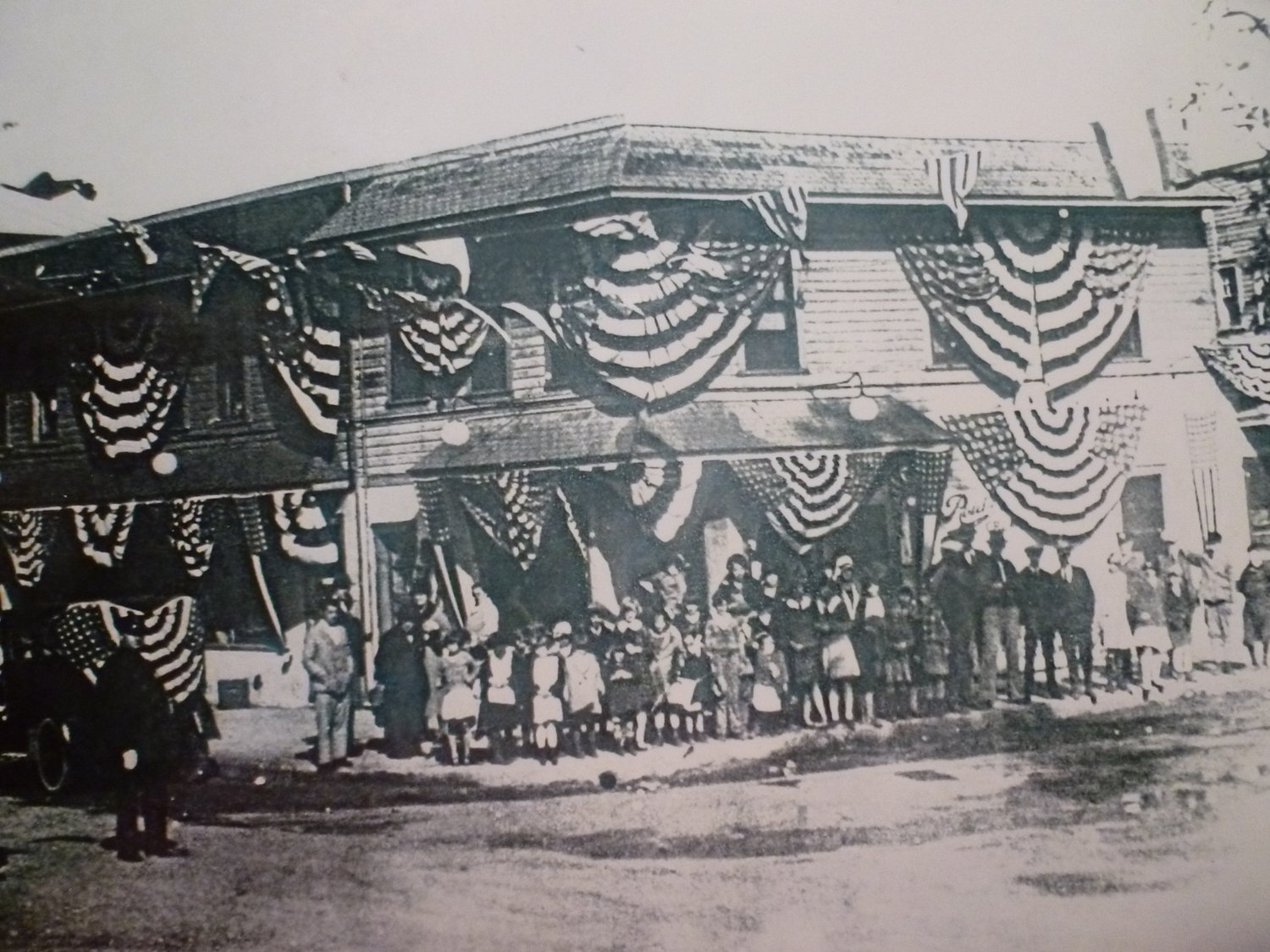 The Woodfield Road-Eagle Avenue corner was first photographed around 1926, when windows belonging to businesses along the block were decorated to celebrate the first electric LIRR train to offer service to Hempstead, which also stopped at the Lakeview station.