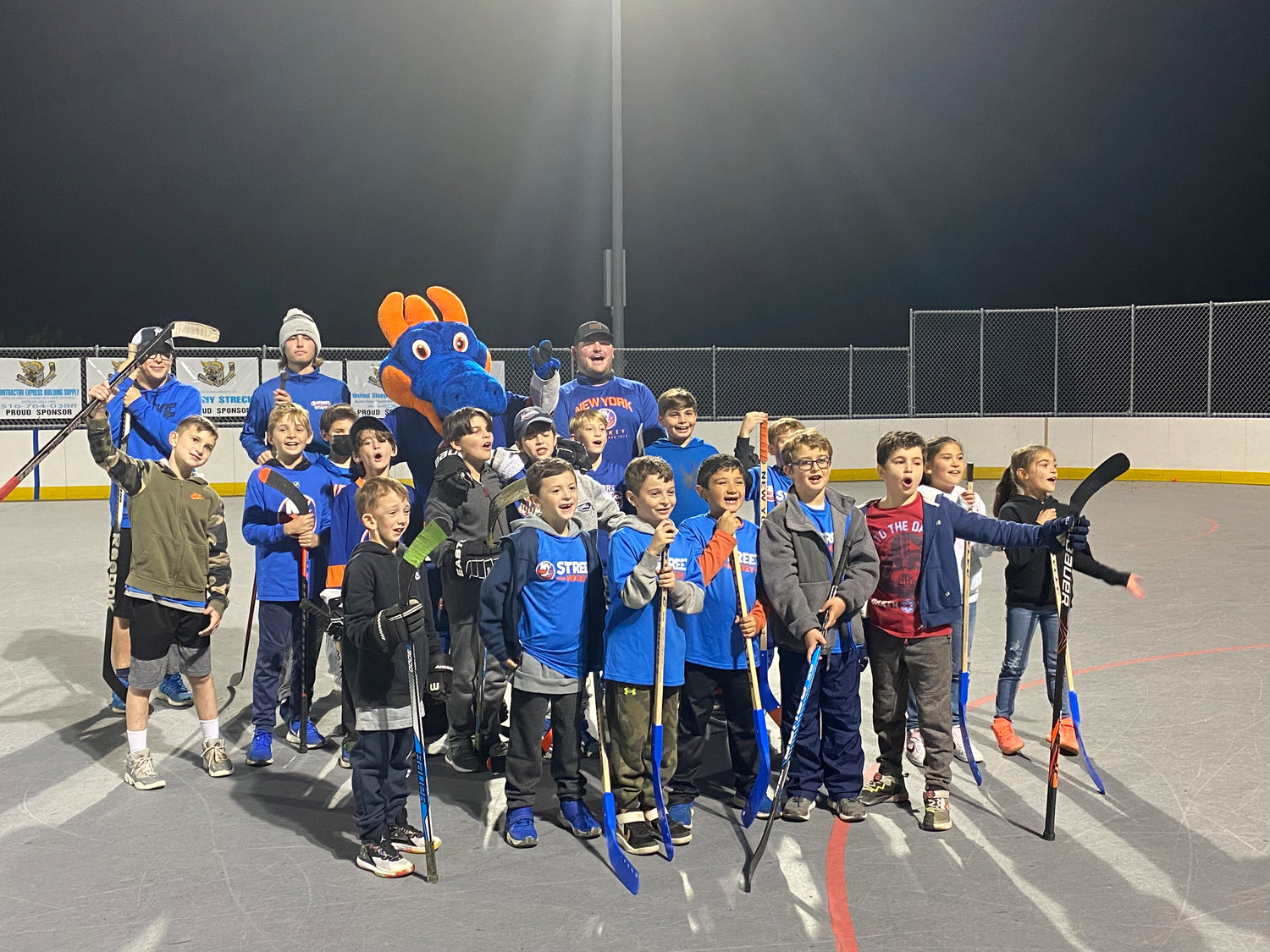The kids celebrate their last session of street hockey lessons at Oceanside Park with New York Islanders staff and Sparky the Dragon.