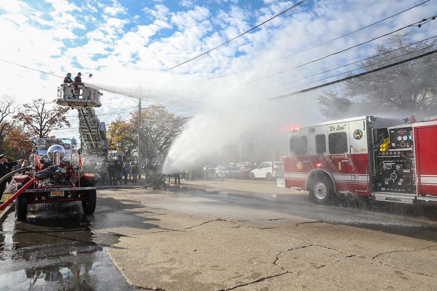 The new fire engine was christened by streams of water from Engine Company's first motorized 1927 pumper, on left, and Lynbrook's bucket truck.