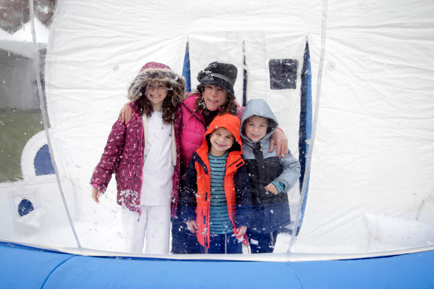 Esther Hammer with Shaindel Rosenberg, 9, Mordecai Rosenberg, 5, and Yechel Moshe, 7, inside the snow globe.