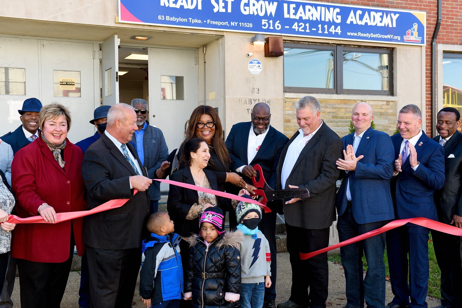 Local officials and church dignitaries attended the grand opening of Ready Set Grow Learning Academy in the Freeport Armory. From left were Bishop Frank Anthone White, of Zion Cathedral in Freeport (behind Hempstead Town Clerk Kate Murray); the Rev. Robert Adams (partially hidden); Freeport Mayor Robert Kennedy; the Rev. Willie J. McGhee (in sunglasses); RSGLA Director Naheed Khan; the academy’s co-owners, Chelisa and Daryl Harris; Chamber of Commerce President Ben Jackson; Hempstead Town Councilman Chris Carini; County Legislator Steve Rhoads, and Bishop Robert Joel Rochford of New Life Cathedral, in Brooklyn, with youngsters from the academy.