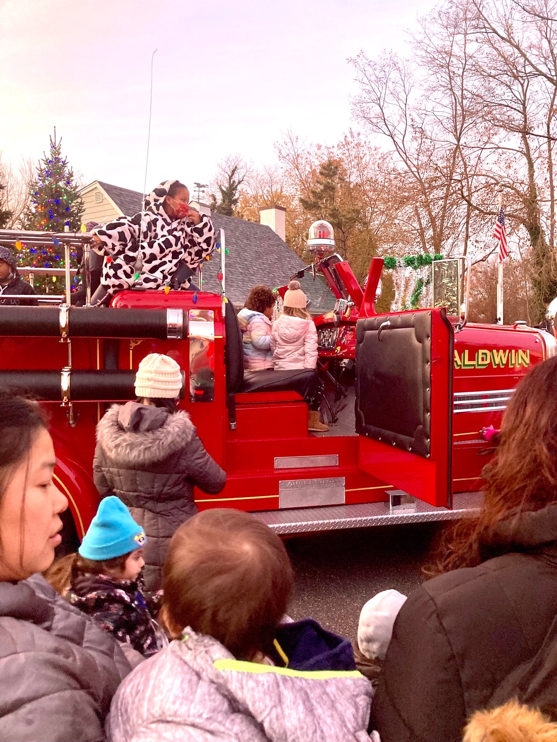 Children watched from atop the Baldwin’s Fire Department old-time fire truck as the evergreen by the Baldwin Historical Society behind it was lit.