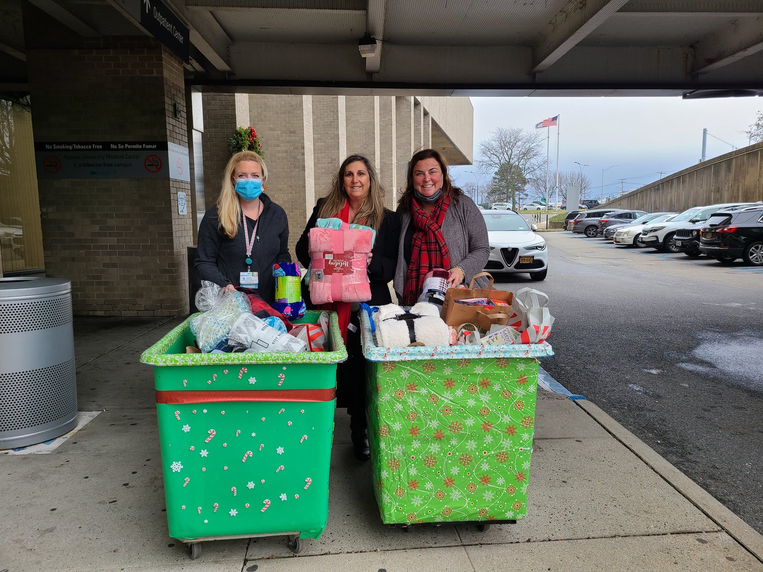 Heather Spanfelner, an activities specialist at NUMC, left, accepted donations from Donna Goldstein, PTA Council president, center, and Kelly Jones, chairwoman of the Books and Blankets Committee.