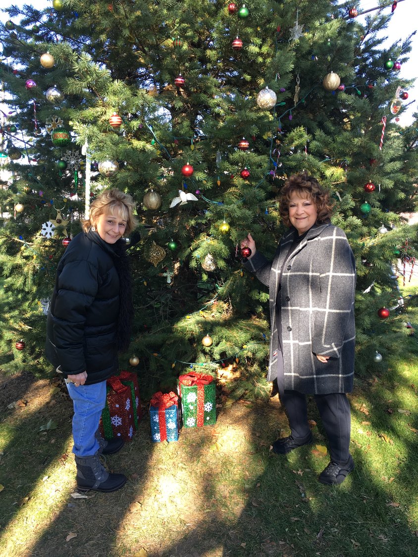 Fries, near right, and Dolores Rome, her best friend, have co-chaired the East Meadow tree lighting for more than 20 years.