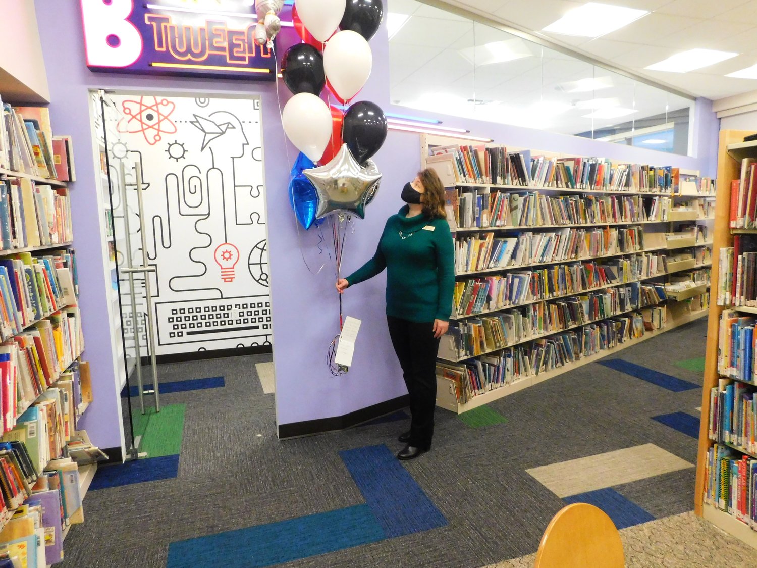 Freeport Memorial LIbrary Director Lee Ann Moltzen adjusted a bunch of celebratory balloons on Dec. 29 for Grand Opening Day of the Inn B Tween Room, one of the projects completed despite the pandemic. CREDIT: Reine Bethany/Herald