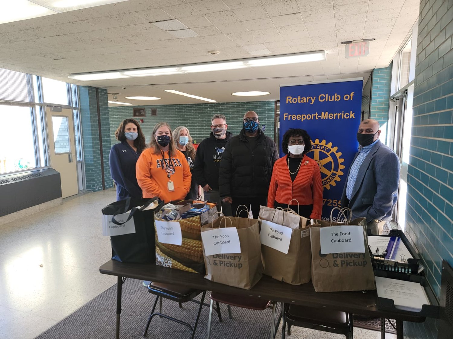 Four members of the Food Cupboard pantry accepted nonperishable items from Freeport-Merrick Rotary Club President Marc Rigueur, incoming Vice-President Comfort Itoka, and Treasurer Ken Dookram.