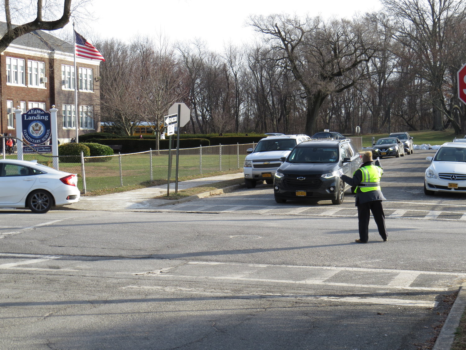 A crossing guard at Landing Elementary School directed traffic after school last Friday.