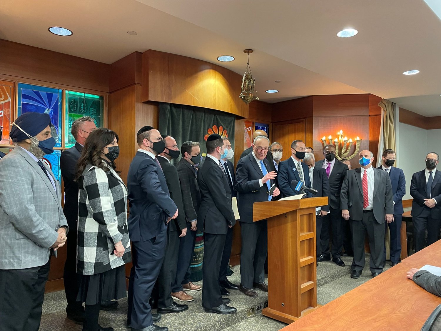 Sen. Charles Schumer, at lectern, surrounded by religious leaders and school administrators, called for doubling the security grant money available for nonprofits.