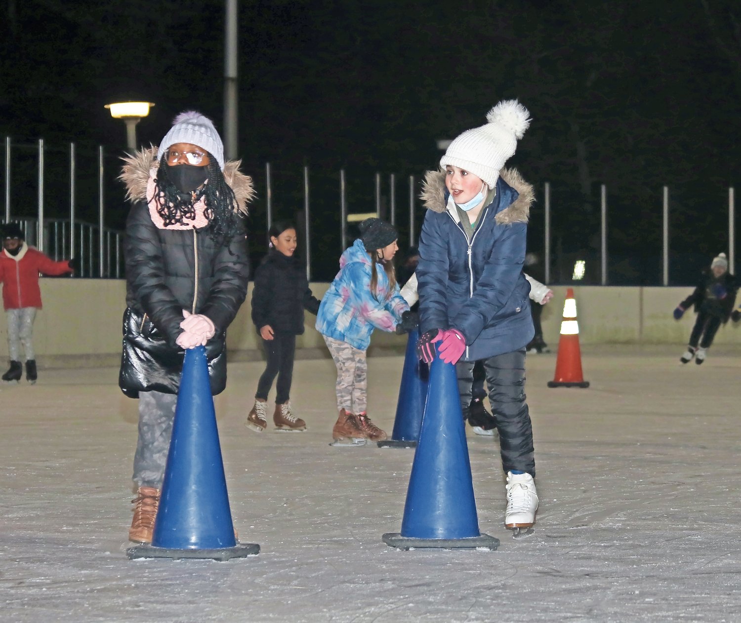 Ogden Elementary School fourth-graders Meryl Jean-Baptiste, left. and Amy Shteinberg used the cones as support in learning how to ice skate.