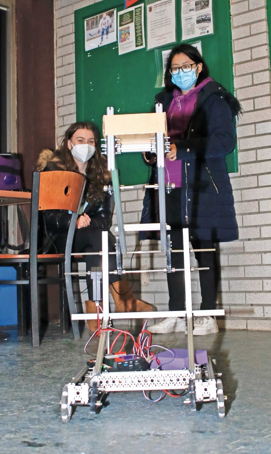 Team Bionica members Anneliese Baum, left, and Zoe Ng showed the Hewlett and Ogden students how the robot operates.