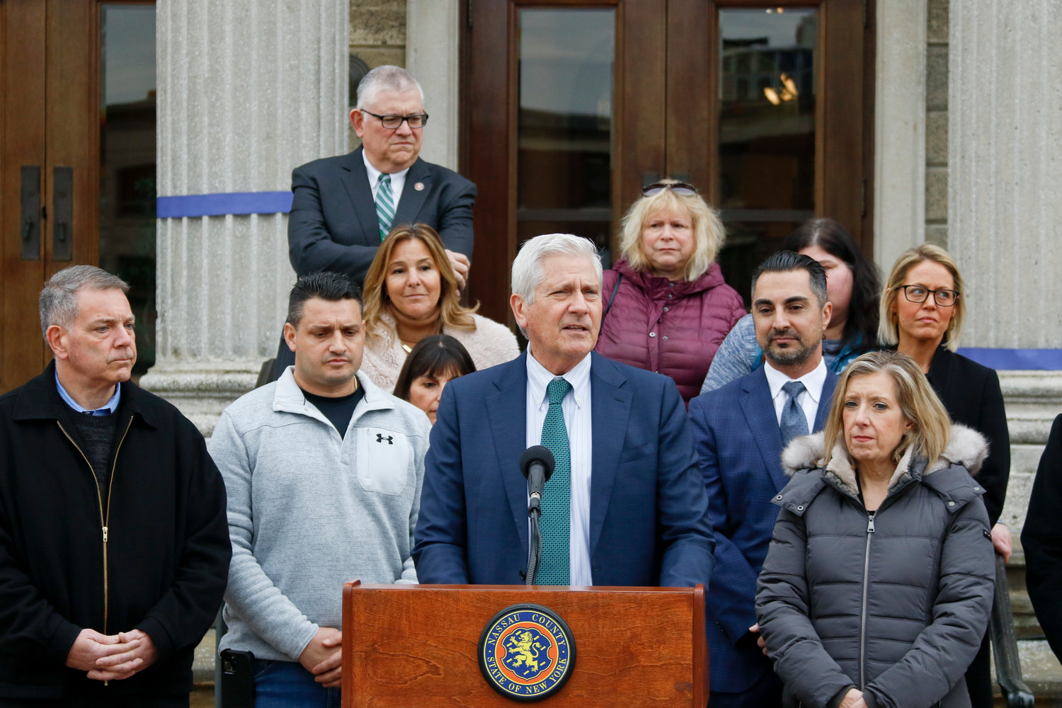 Nassau County Legislator Steve Rhoads, left, joined County Executive Bruce Blakeman as he announced support for a ruling against Gov. Kathy Hochul’s state mask mandate. To Blakeman’s left was Michael Demetriou, the lead plaintiff in the case against the mandate. They are surrounded by members of local school boards and a Wantagh parent expressing opposition to the mask mandate.