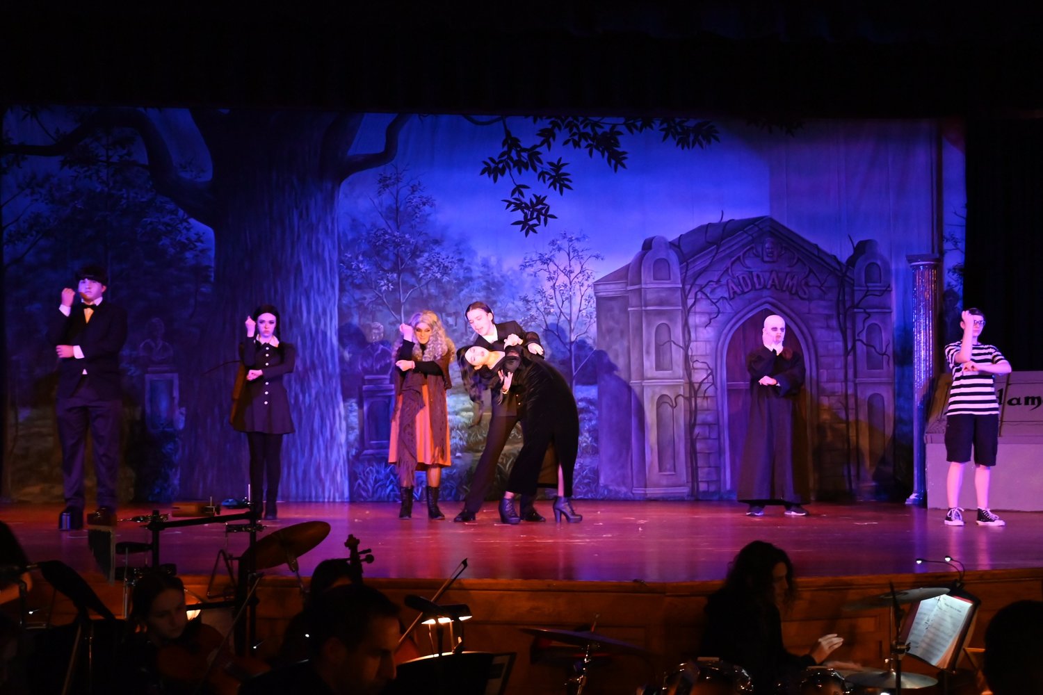Ava Lithgow as Morticia and Patrick O’Neill as Gomez doing the Tango as other members of The Addams Family watched.
