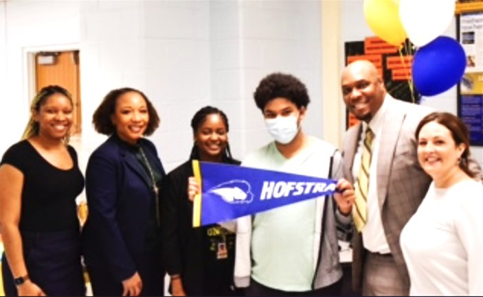 Surrounded by school administrators including Superintendent Monique Darrisaw-Akil, second from left, Javier Berrios celebrated his acceptance to Hofstra.
