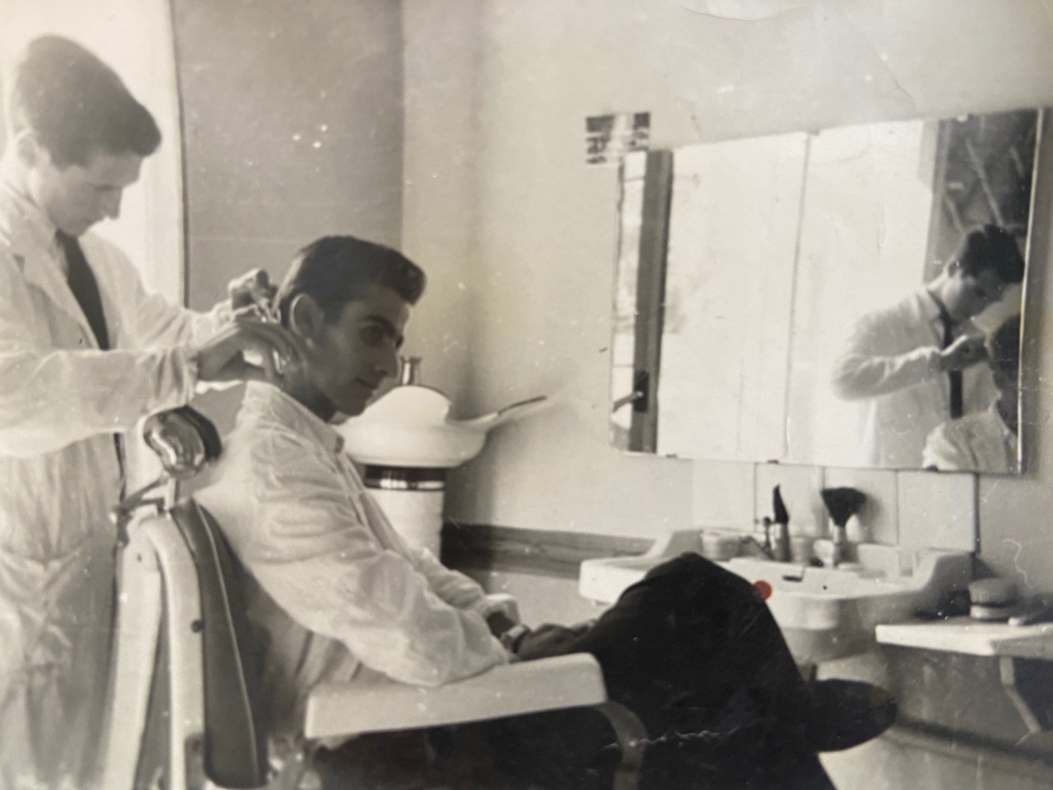 Nick Oricchio, left, working at a barbershop in Italy at age 17