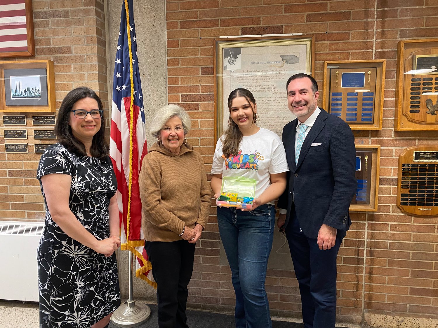 Hispanic Brotherhood’s Marguerite Keller, far left, and Marguerite Grasing received 75 boxes of art supplies from Oceanside High School junior Lauren Oliver on April 6 with Dr. David Rose, who connected Oliver with the organization.