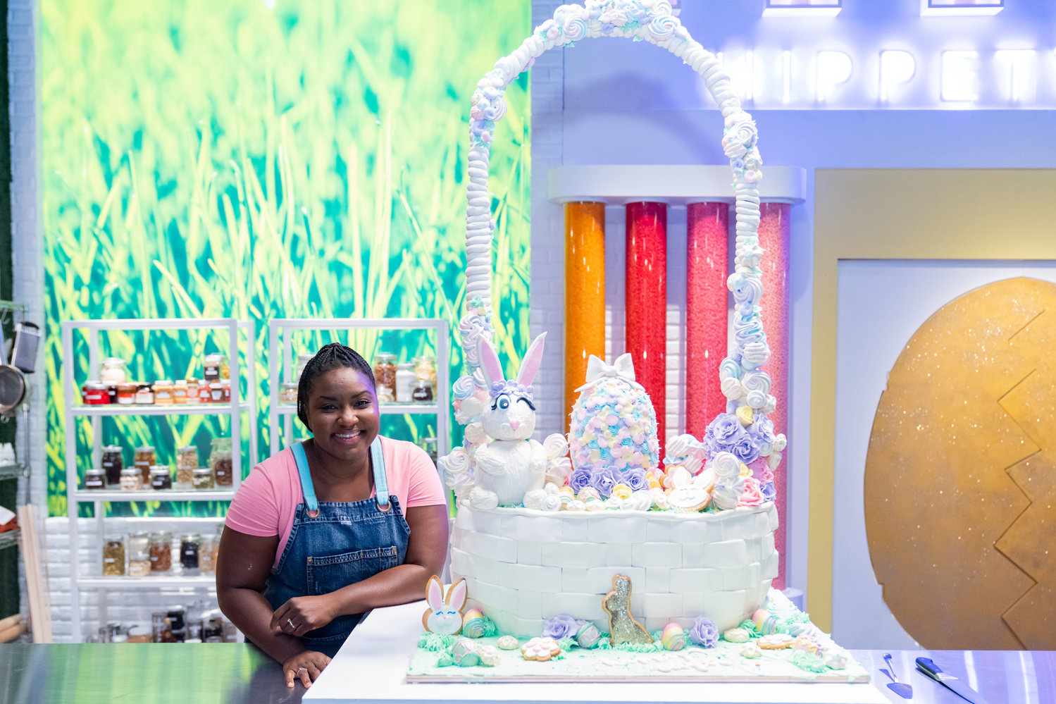 West Hempstead Bakery owner Sydney Perry, a South Floral Park resident, with her 4-foot-tall Easter basket cake, for which she was named champion in the Food Network’s “Spring Baking Championship: Easter” competition.
