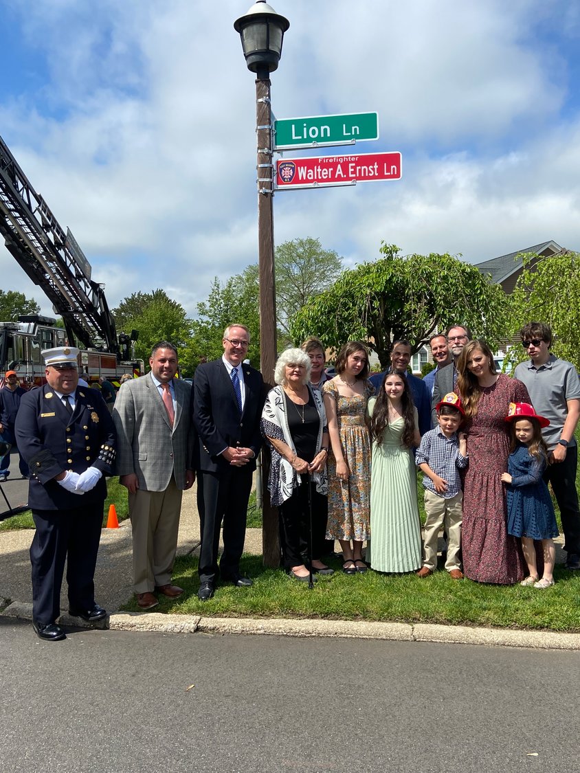 Family, friends, East Meadow Fire Department members and town officials gathered around, and Walter Ernst’s widow, Linda, pulled the rope that unveiled the sign.