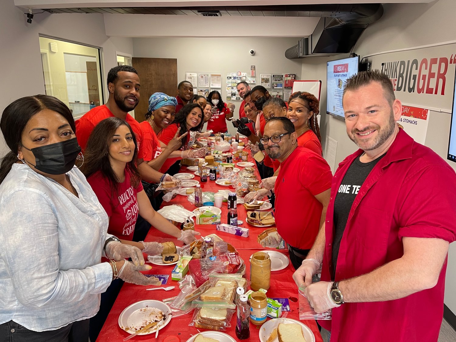 Brian Wells, right, a team leader at Keller Williams’ Franklin Square location, and various agents at the company preparing peanut butter and jelly sandwiches before the May 12 event.