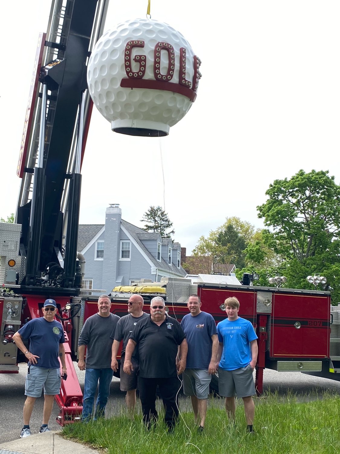 The Baldwin Fire Department with Baldwin Historical Society president Gary Farkash (third from left) practicing placing the fiberglass golf ball from Nunley’s Amusement Park.