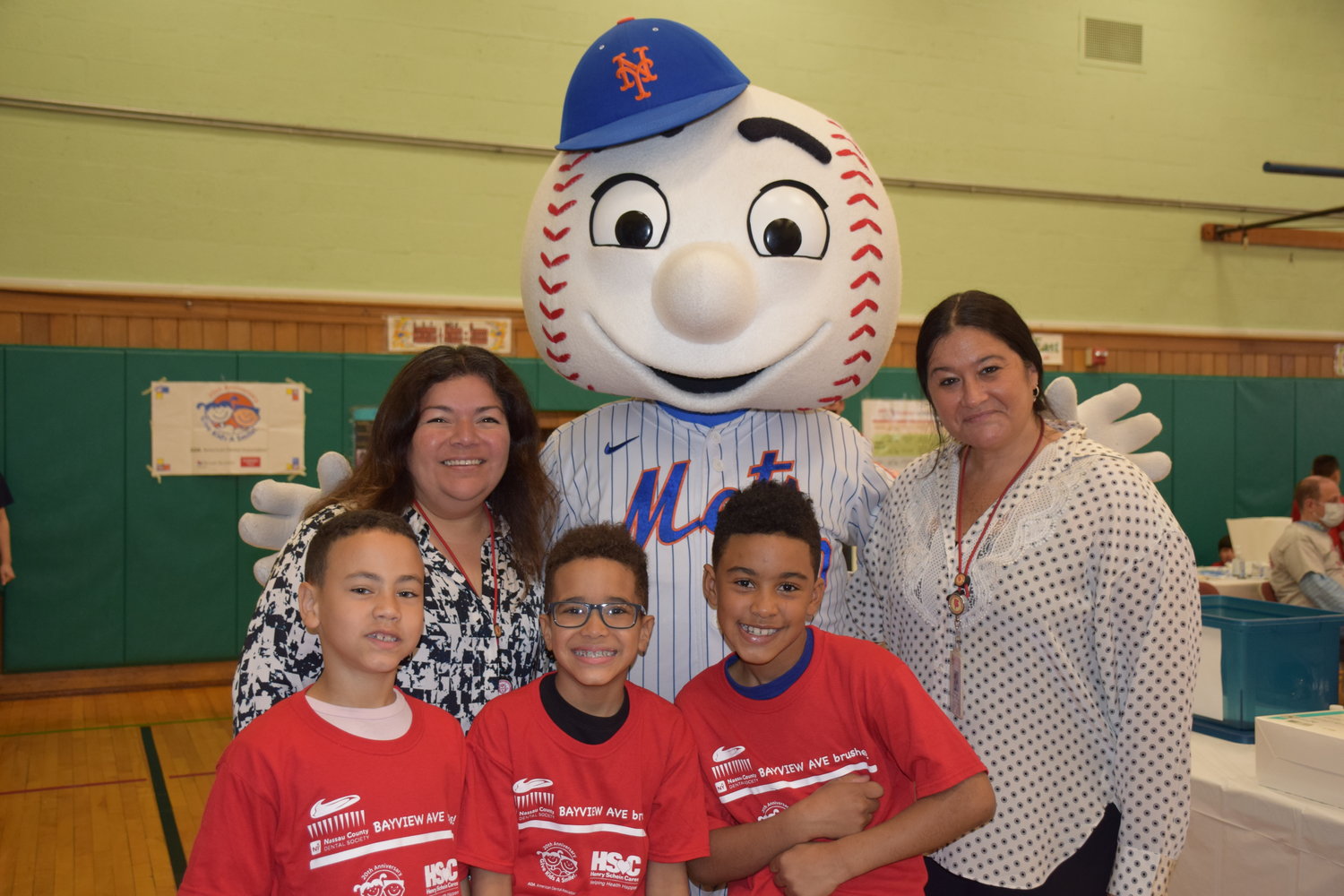 Freeport Public Schools Board of Education President Maria Jordan-Awalom (left), Assistant Superintendent for Curriculum and Instruction, Glori Engel (right) and Bayview Avenue students greeted Mr. Met at Give Kids a Smile Day.