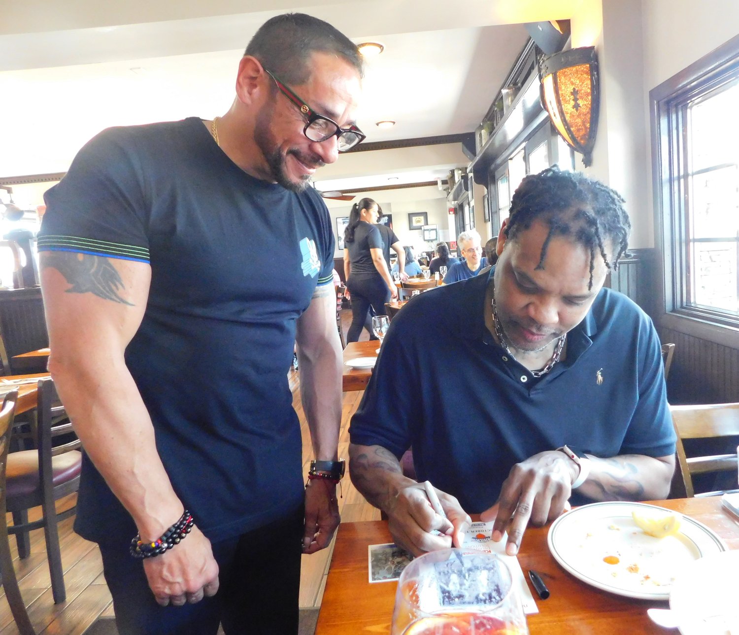 Former NBA star Latrell Sprewell, right, signed autographs for fans at the River House Grille at the 32nd Annual Nautical Mile Festival on June 4.