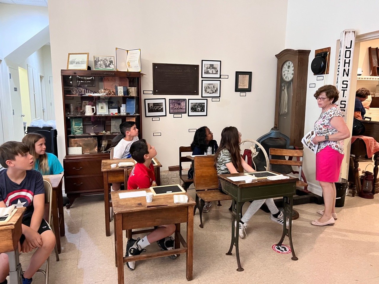 Students sat at desks used at Franklin Square schools up to 100 years ago and learned about the history of the former Monroe Street School in Franklin Square that was torn down in 1980.
