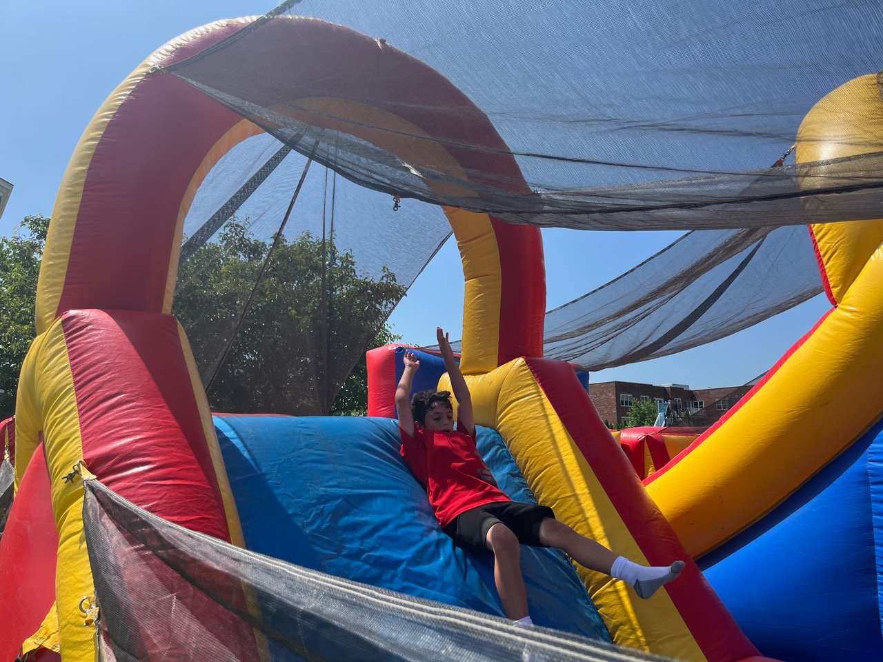 Second grade student Matthew Sasso sliding down the bouncy obstacle course.