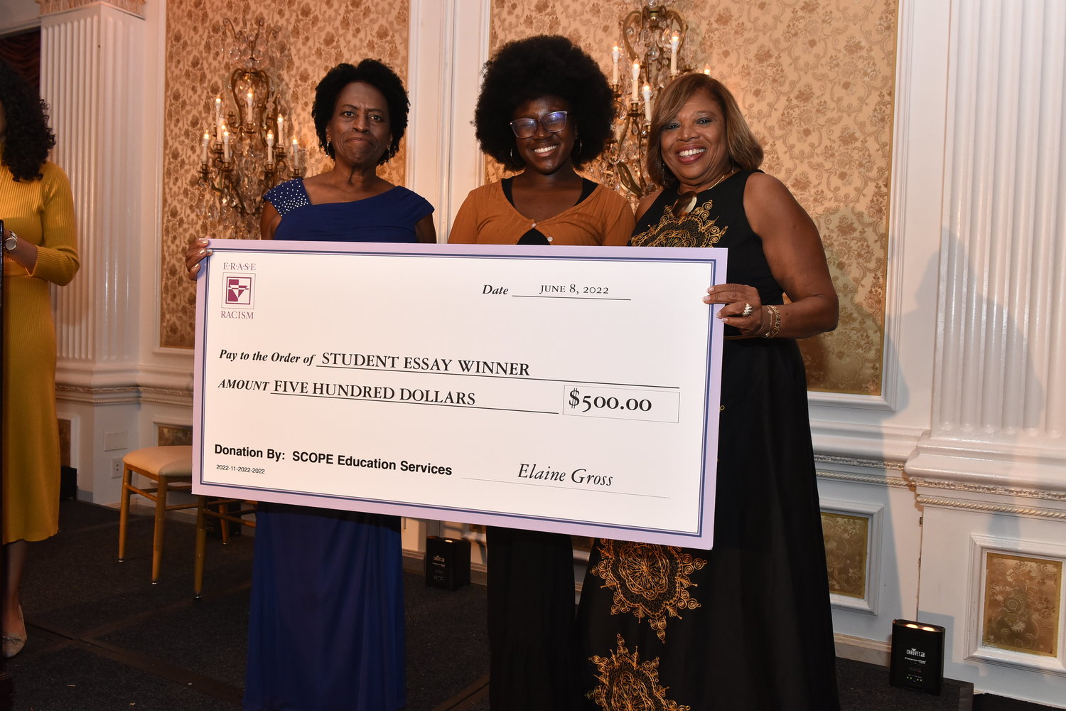 Kayla George receives her scholarship accompanied by ERASE Racism president V. Elaine Gross, and Malverne superintendent Lorna Lewis.