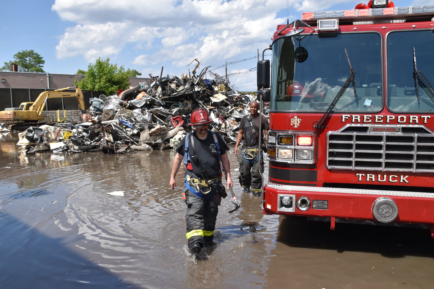 Firefighters slogged through a huge puddle generated by the water that had to be pumped for over and hour to drown a fire in the huge rubbish pile behind a building on Hanse Avenue.