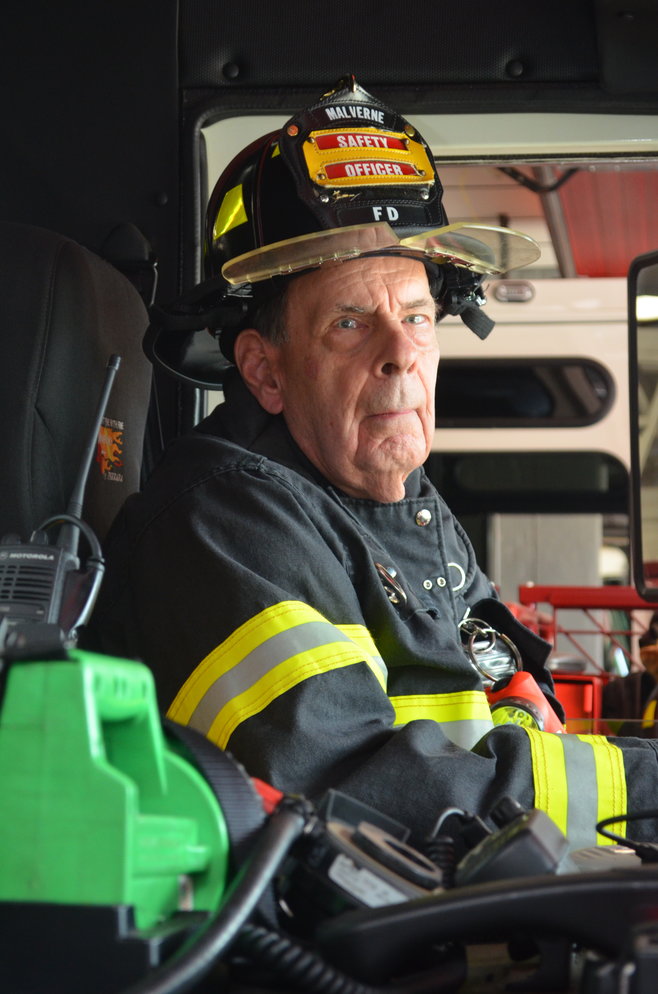 Firefighter Dave Weinstein sits behind the wheel of a fire engine at the Malverne Fire Department.
