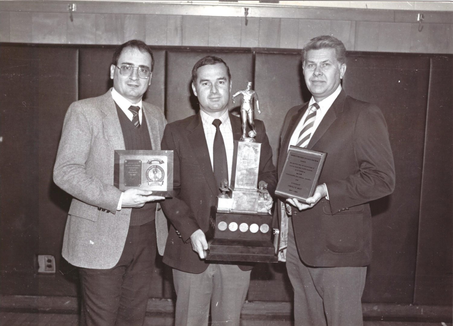 Tom O’Leary, center, with then-superintendent Carl Bonuso, far left, and former athletic director Paul Schotte after O’Leary won a Coach of the Year Award.