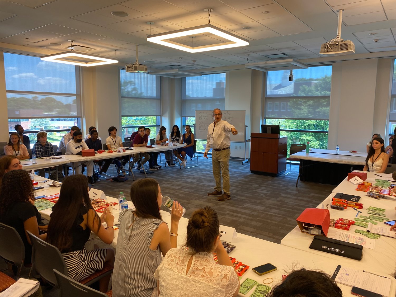 Molloy University professor Bruce Haller delivered news to keep the students in Molloy University's Business Boot Camp on their toes during a mock Wall Street trading exercise.