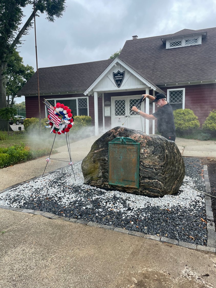 Eric Spinner power-washed the rock that holds the plaque to remove mold, moss and patina, a green film that forms naturally on copper or brass.