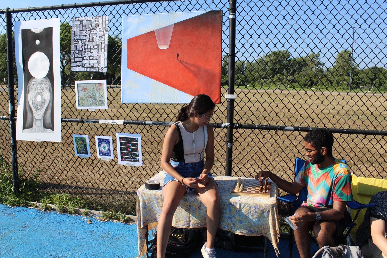 Emma Wong and Joshua Matthews played chess in front of Wong’s art in the skate park.