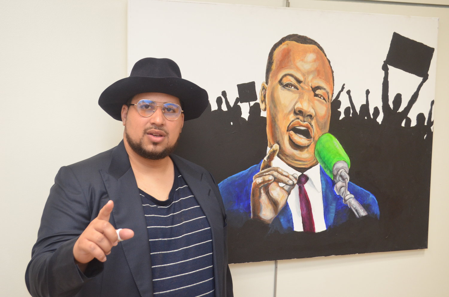 Ron McHenry, the first Black artist to hold a solo show at the Long Beach Public Library, with a portrait of the Rev. Dr. Martin Luther King Jr.