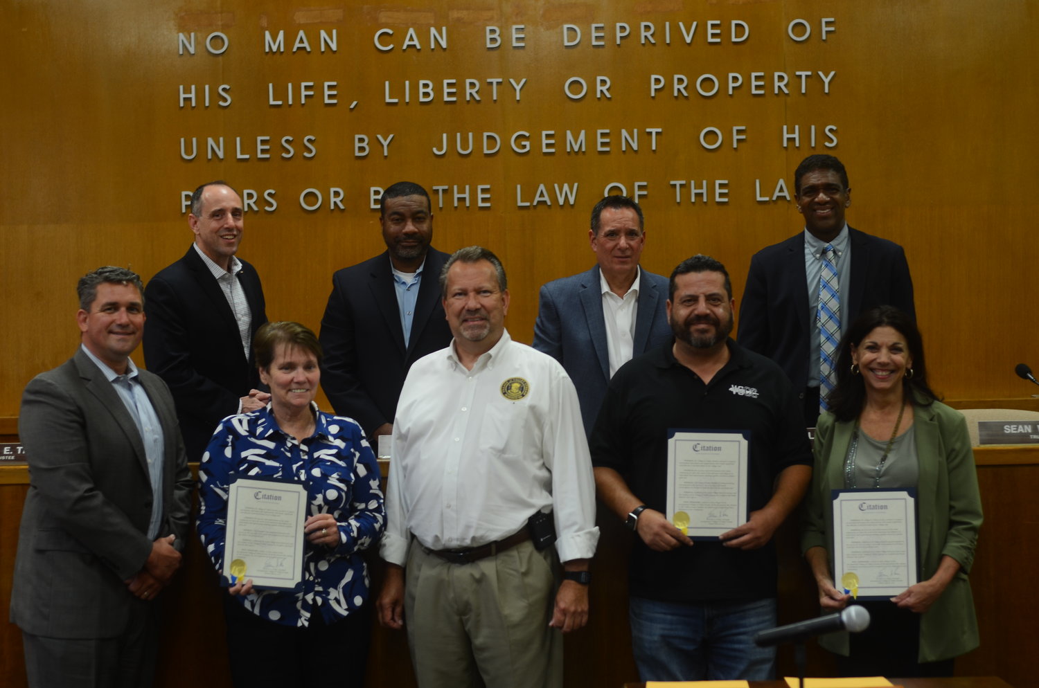 Mayor Edwin Fare, middle, presented village citations to three organizations for their help during the annual Independence Day fireworks display. Chamber of Commerce President Sasan Shavanson, second front from right, and representatives from WeTransport, first front from right, were there to receive citations.