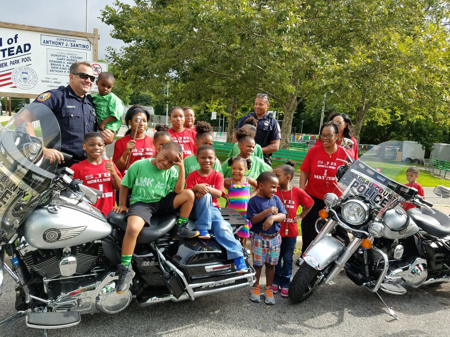Two officers of the Lakeview Police Department with their motorcycles and community members at the 2021 Lakeview Day.