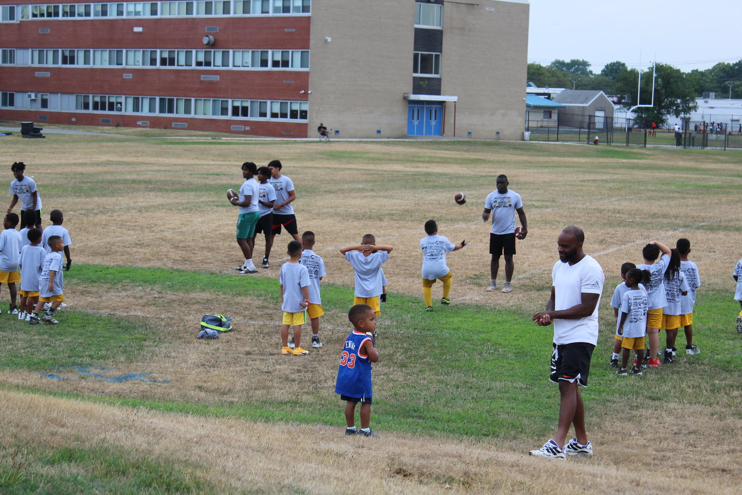 Five-year-olds caught footballs tossed to them by Baldwin High School senior Kwasi Bonsu at the skills clinic July 27.