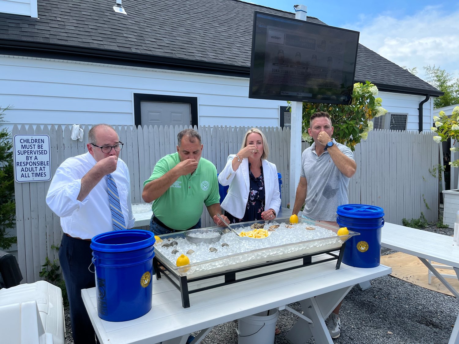 Town Clerk Rich LaMarca, far left, Supervisor Joseph Saladino, Councilwoman Laura Maier and Cooper Bluff owner Russ Lundstrom ate the first oysters. The shells were later put in a bucket for the new program.