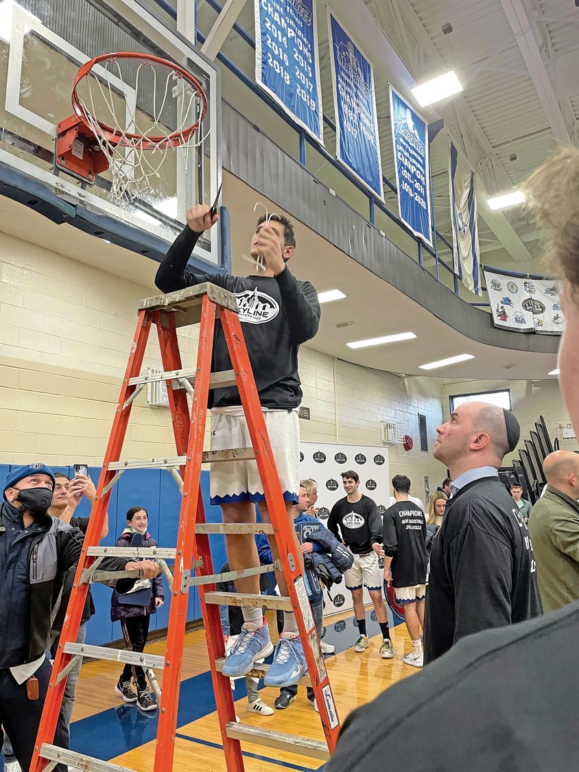 Yeshiva University men’s basketball head coach Elliot Steinmetz will receive the first-ever the Jewish Sports Heritage Association’s Marty Riger Outstanding Jewish Coach of the Year Award. Above, Steinmetz watched Lawrence native Gabriel Leifer cut the net after winning the 2021-2022 Skyline Conference title.
