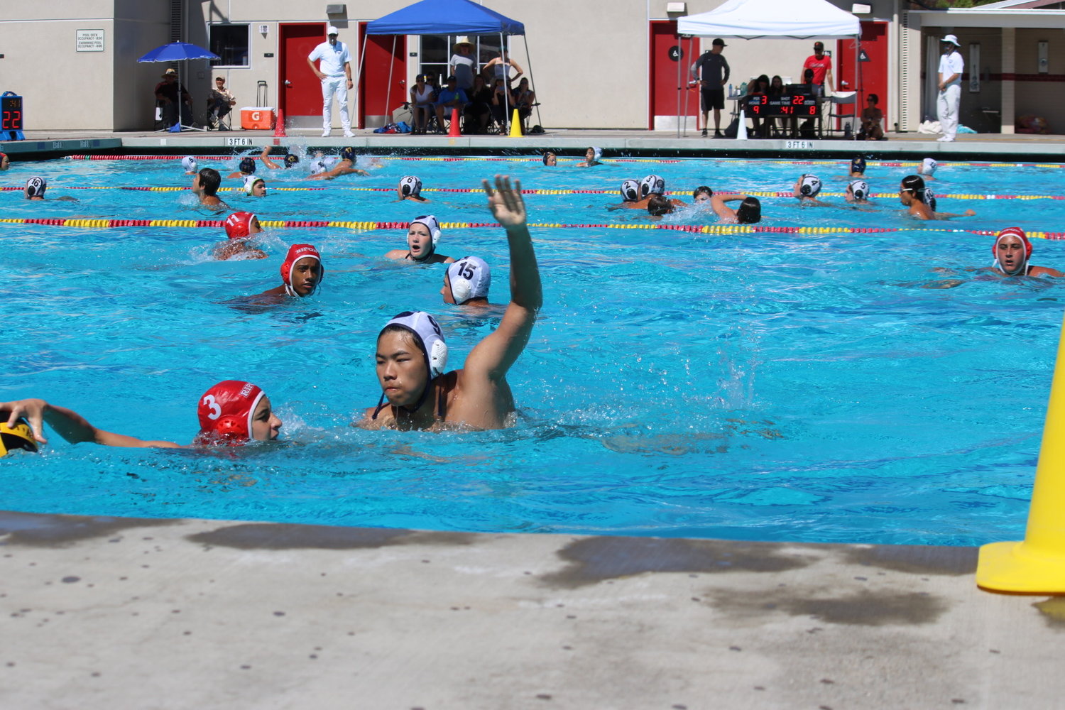 Lucas Xiao Lu, number 9, reached over an opponent during a water polo match in San Jose during the 2022 Summer Junior Olympics.