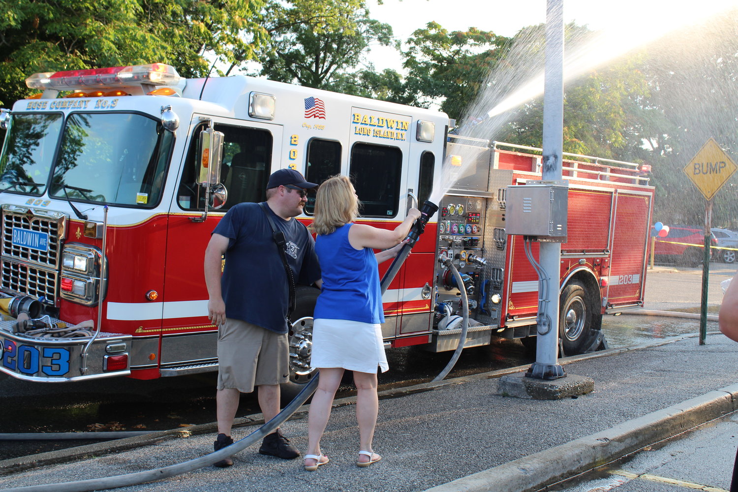 County Legislator Debra Mulé tried out the Baldwin Fire Department hose.