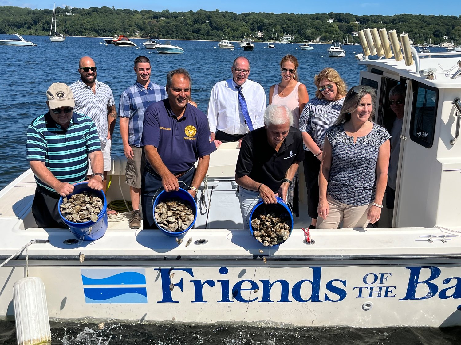 Public officials and oyster gardening program volunteers gathered on the Friends of the Bay’s boat to clean and measure the oysters one final time.